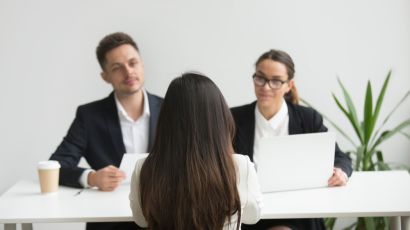 Female candidate getting interviewed by two people, one man and one woman