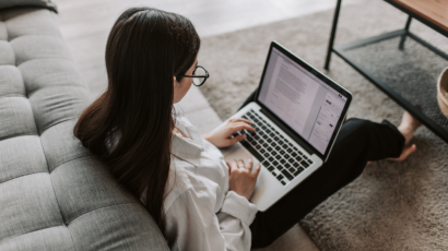 female woman working on her laptop while sitting on the floor at home