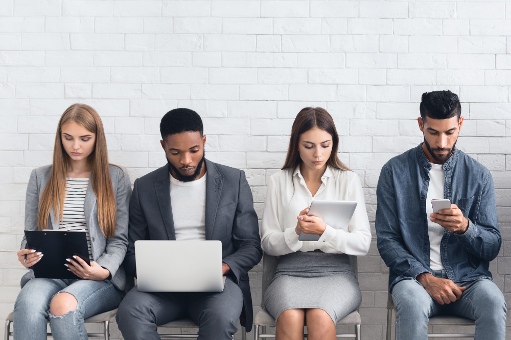 Four people (two women and two men) are sitting and waiting for the interview