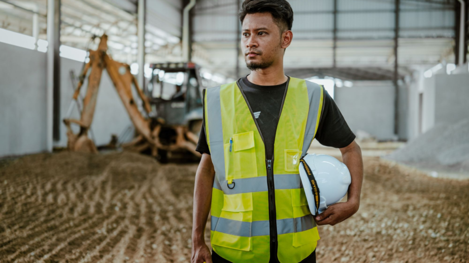 Latin American male industrial worker holding a helmet