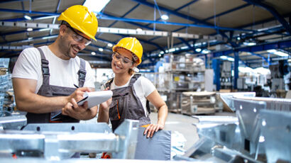 Warehouse workers checking products in a large industrial hall during a busy season