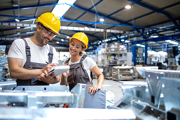 Warehouse workers checking products in a large industrial hall during a busy season